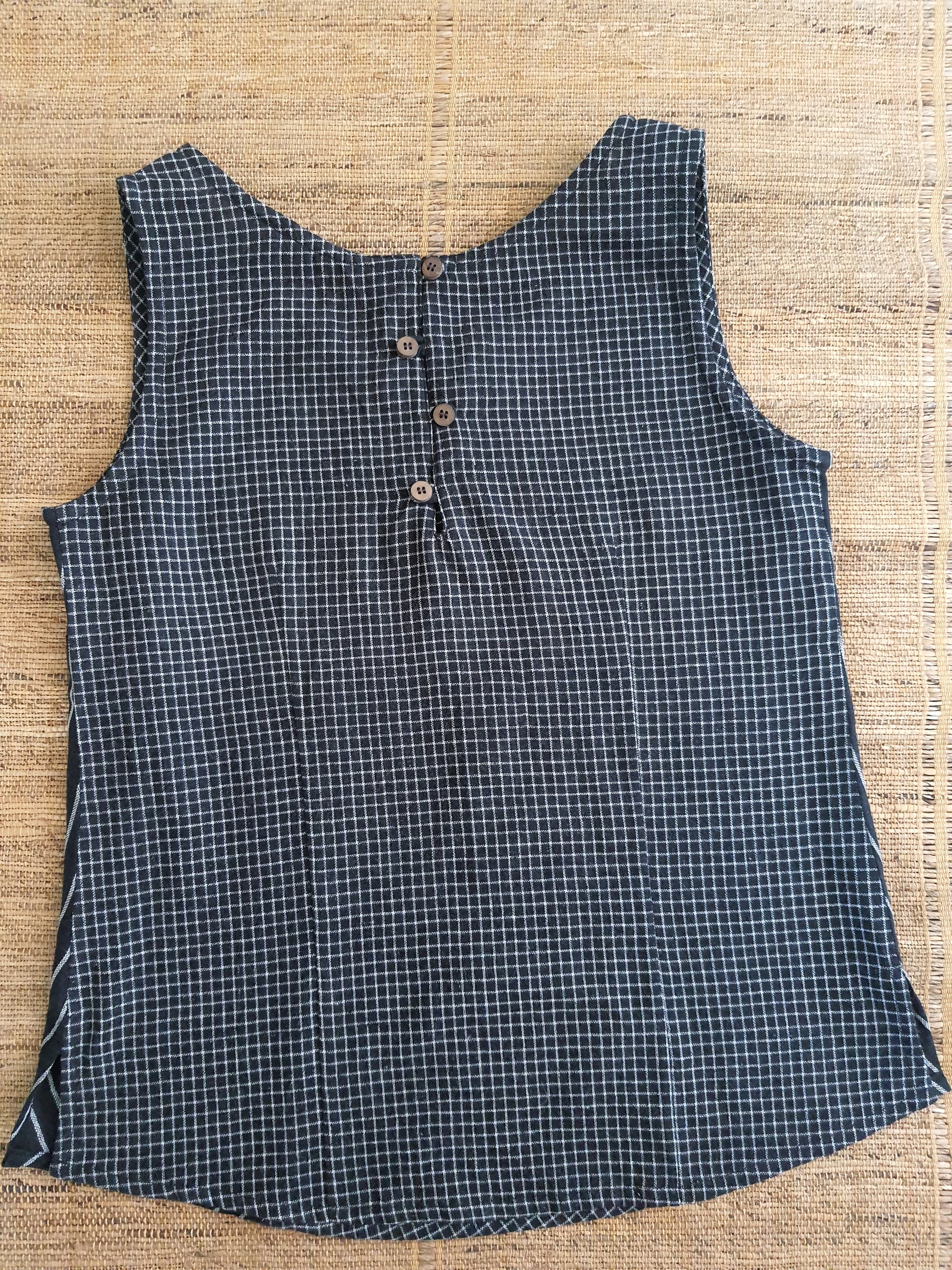 Image of the back of the top. black white checks. loop and button detailing