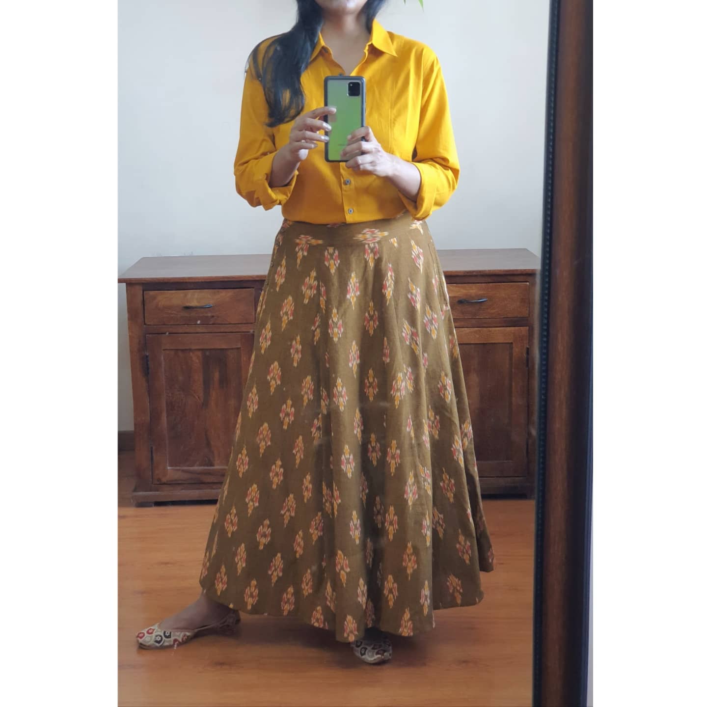 picture of a woman in a turmeric shirt paired with caramel ikkat full length skirt