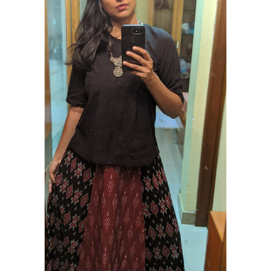 Picture of a woman in a black top with long ikkat skirt